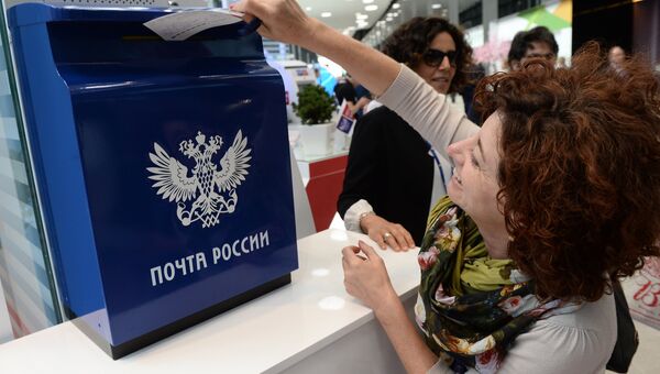Посетительница XX Петербургского международного экономического форума опускает открытку в ящик Почты России Посетительница XX Петербургского международного экономического форума опускает открытку в ящик Почты России
