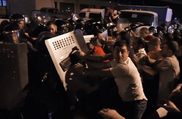 Протестующие во время столкновения с полицейскими на улице близ захваченного в Ереване здания полка патрульно-постовой службы Протестующие во время столкновения с полицейскими на улице близ захваченного в Ереване здания полка патрульно-постовой службы