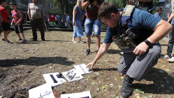 Представитель Специальной мониторинговой миссии ОБСЕ осматривают воронку от снаряда во время фиксации разрушений в Ясиноватой. Архивное фото Представитель Специальной мониторинговой миссии ОБСЕ осматривают воронку от снаряда во время фиксации разрушений в Ясиноватой. Архивное фото