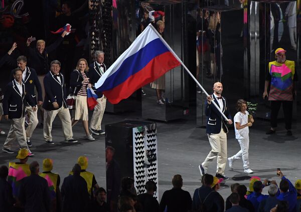 Знаменосец сборной России Сергей Тетюхин несет российский флаг на церемонии открытия летних Олимпийских игр в Рио Знаменосец сборной России Сергей Тетюхин несет российский флаг на церемонии открытия летних Олимпийских игр в Рио