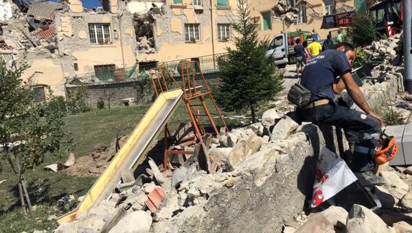 Люди у разрушенных в результате землетрясения домов в городе Аматриче Люди у разрушенных в результате землетрясения домов в городе Аматриче