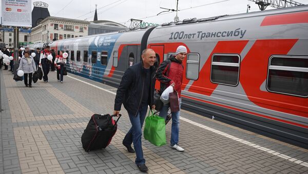 Пассажиры у поезда Россия рейса Москва – Владивосток на перроне Ярославского вокзала в Москве Пассажиры у поезда Россия рейса Москва – Владивосток на перроне Ярославского вокзала в Москве