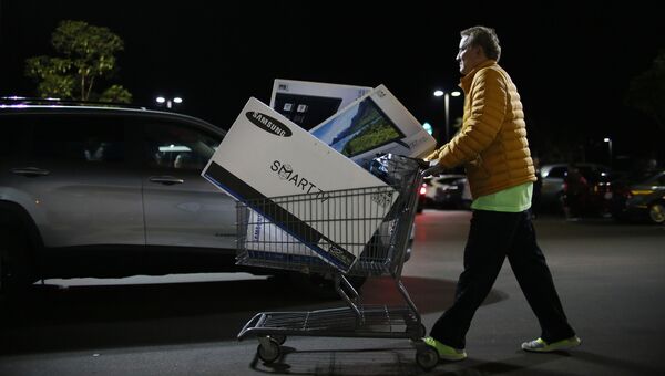 Покупатель выходит из магазина во время распродажи в Черную пятницу в Сан-Диего, штат Калифорния, США Покупатель выходит из магазина во время распродажи в Черную пятницу в Сан-Диего, штат Калифорния, США