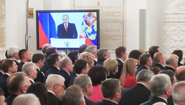 Экран с трансляцией выступления президента России Владимира Путина с ежегодным посланием Федеральному Собранию РФ в Георгиевском зале Кремля. 1 декабря 2016 Экран с трансляцией выступления президента России Владимира Путина с ежегодным посланием Федеральному Собранию РФ в Георгиевском зале Кремля. 1 декабря 2016