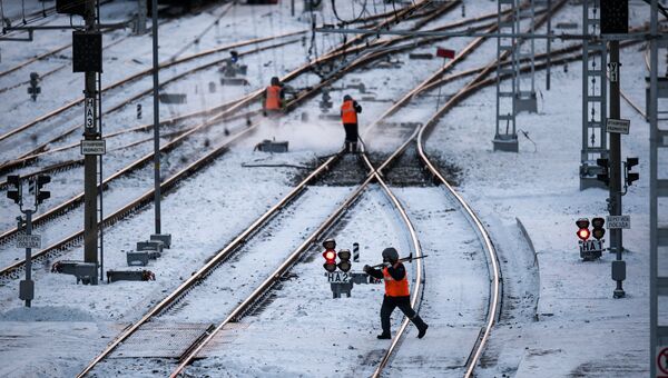 Рабочие очищают железнодорожный путь на станции Омск-Пассажирский в Омске Рабочие очищают железнодорожный путь на станции Омск-Пассажирский в Омске