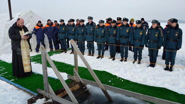 Священнослужитель освящает крещенскую купель, подготовленную сотрудниками МЧС РФ, на льду Амурского залива во Владивостоке Священнослужитель освящает крещенскую купель, подготовленную сотрудниками МЧС РФ, на льду Амурского залива во Владивостоке