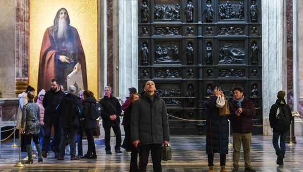 Туристы на экскурсии в Исаакиевском соборе. На втором плане - икона с изображением святого Исаакия Туристы на экскурсии в Исаакиевском соборе. На втором плане - икона с изображением святого Исаакия