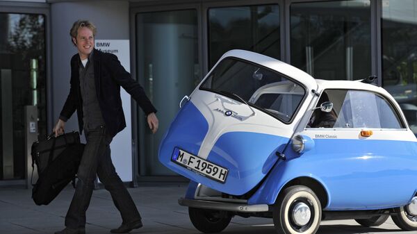 Посетитель музея BMW у автомобиля BMW Isetta