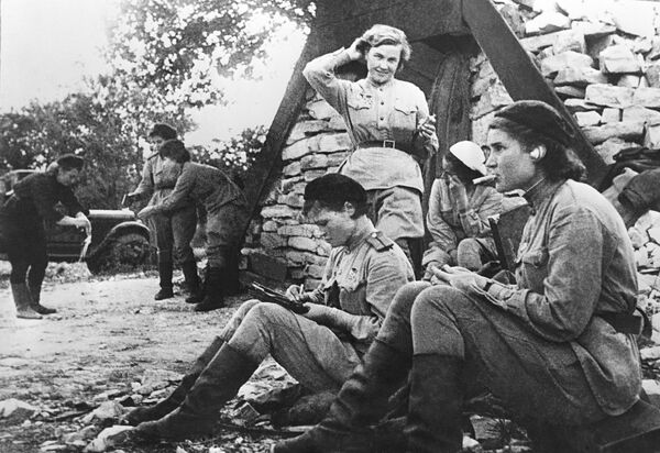 Лётчицы 46-го гвардейского авиационного полка после дневного отдыха у землянки Лётчицы 46-го гвардейского авиационного полка после дневного отдыха у землянки