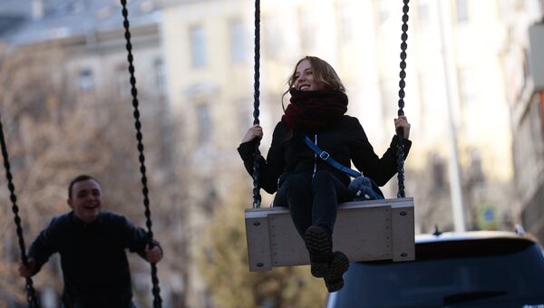 Молодые люди катаются на качелях в Москве Молодые люди катаются на качелях в Москве