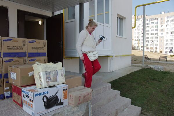 Женщина заселяется в новый дом в Крыму, построенный для переселенцев из зоны строительства Керченского моста Женщина заселяется в новый дом в Крыму, построенный для переселенцев из зоны строительства Керченского моста