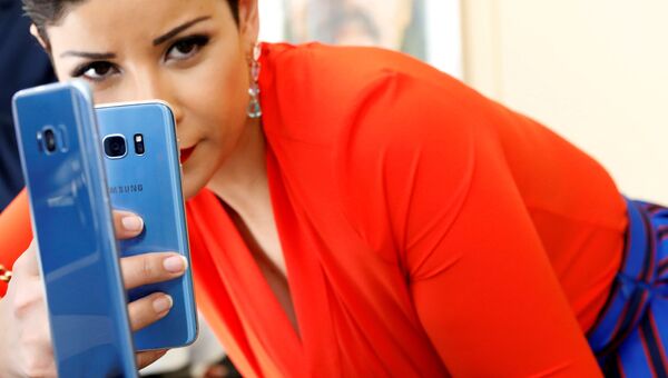 Девушка фотографирует смартфон Samsung Galaxy S8 + с Galaxy S7 на презентации в Нью-Йорке Девушка фотографирует смартфон Samsung Galaxy S8 + с Galaxy S7 на презентации в Нью-Йорке