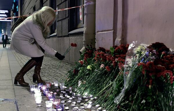 Женщина возлагает цветы рядом со станцией метро Технологический институт в память о погибших в результате взрыва в метро Санкт-Петербурга Женщина возлагает цветы рядом со станцией метро Технологический институт в память о погибших в результате взрыва в метро Санкт-Петербурга