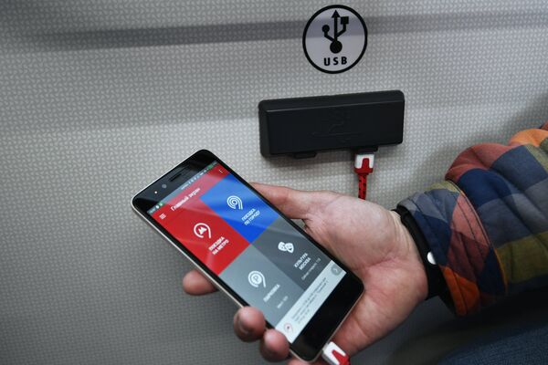 Пассажир заряжает телефон в салоне нового электробуса в Москве Пассажир заряжает телефон в салоне нового электробуса в Москве