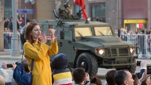 Девушка во время прохода военной техники по Тверской улице перед репетицией парада Победы на Красной площади Девушка во время прохода военной техники по Тверской улице перед репетицией парада Победы на Красной площади