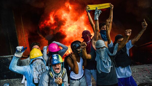 Протестующие подожгли здание Верховного суда во время митинга против президента Николаса Мадуро в Каракасе Протестующие подожгли здание Верховного суда во время митинга против президента Николаса Мадуро в Каракасе