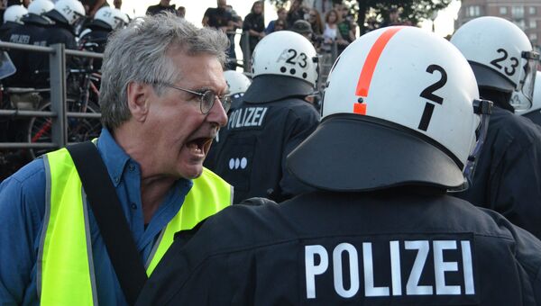 Участник акции протеста (слева) в преддверии саммита G20 в Гамбурге Участник акции протеста (слева) в преддверии саммита G20 в Гамбурге
