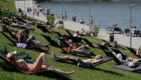 Москвичи в выходной день отдыхают на Воробьевых горах. Архивное фото Москвичи в выходной день отдыхают на Воробьевых горах. Архивное фото