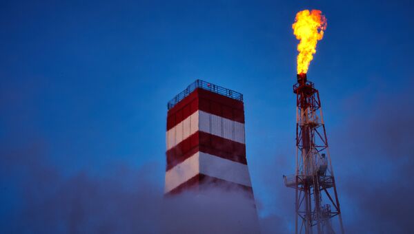 Буровая вышка и газовый факел морской нефтеперерабатывающей платформы. Архивное фото Буровая вышка и газовый факел морской нефтеперерабатывающей платформы. Архивное фото