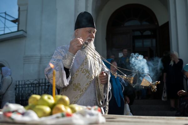 Священнослужитель и верующие во время богослужения в честь праздника Преображения Господня у собора Воздвижения Креста Господня в Омске. 19 августа 2017 Священнослужитель и верующие во время богослужения в честь праздника Преображения Господня у собора Воздвижения Креста Господня в Омске. 19 августа 2017