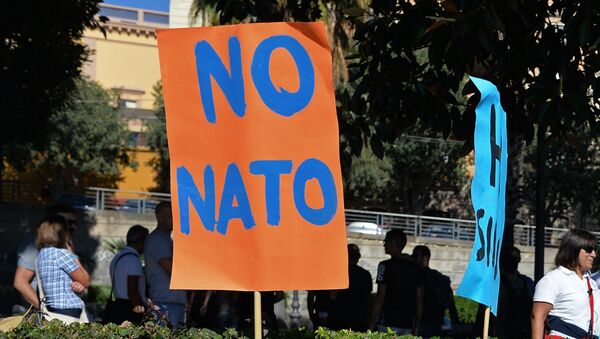 Плакаты на акции протеста против учений НАТО в итальянском городе Кальяри. 14 октября 2014 Плакаты на акции протеста против учений НАТО в итальянском городе Кальяри. 14 октября 2014