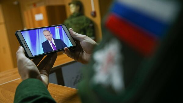 Военнослужащий смотрит трансляцию выступления президента РФ Владимира Путина на заседании клуба Валдай Военнослужащий смотрит трансляцию выступления президента РФ Владимира Путина на заседании клуба Валдай