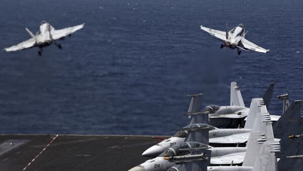 Истребители США F / A-18 вылетают с летной палубы авианосца. Архивное фото Истребители США F / A-18 вылетают с летной палубы авианосца. Архивное фото