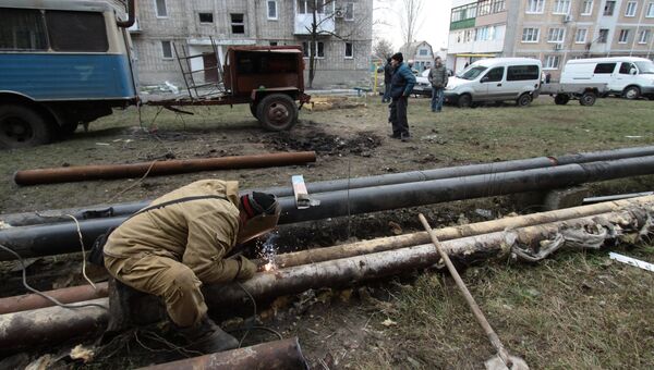 Сотрудник ЖКХ ремонтирует трубы жилого дома в городе Ясиноватая, пострадавшего в результате обстрела. 21 декабря 2017 Сотрудник ЖКХ ремонтирует трубы жилого дома в городе Ясиноватая, пострадавшего в результате обстрела. 21 декабря 2017