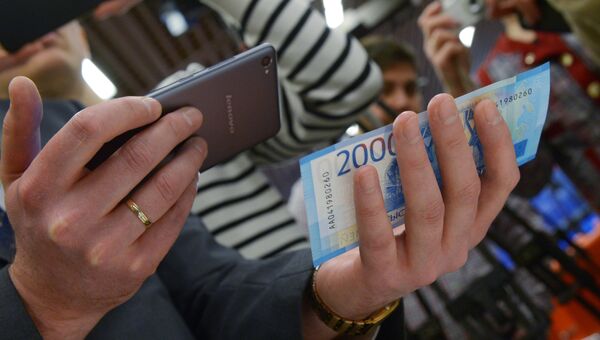 Мужчина сканирует купюру телефоном, на котором установлено новое мобильное приложение АО Гознак - Банкноты 2017 Мужчина сканирует купюру телефоном, на котором установлено новое мобильное приложение АО Гознак - Банкноты 2017