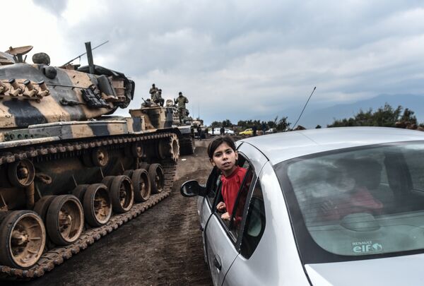 Турецкая девочка выглядывает из окна автомобиля во время стягивания войск турецкой армии к границе с Сирией Турецкая девочка выглядывает из окна автомобиля во время стягивания войск турецкой армии к границе с Сирией