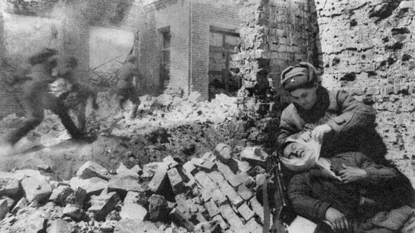 Сталинград. Декабрь 1942 г. Уличный бой. Санитарка перевязывает раненого Сталинград. Декабрь 1942 г. Уличный бой. Санитарка перевязывает раненого