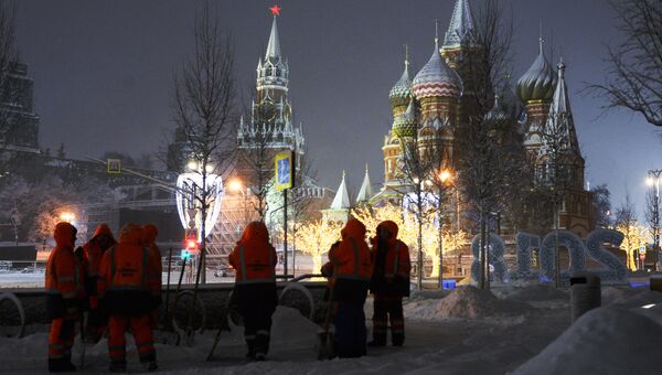 Сотрудники коммунальных служб убирают снег на улице в Москве Сотрудники коммунальных служб убирают снег на улице в Москве