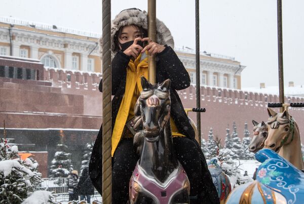 Туристка из Китая на карусели на Красной площади Туристка из Китая на карусели на Красной площади