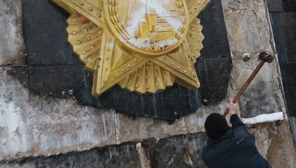 Националист сбивает облицовку на Монументе Славы во Львове Националист сбивает облицовку на Монументе Славы во Львове