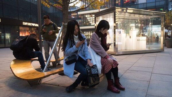 Горожане на территории многофункционального комплекса Sanlitun Soho в Пекине. Архивное фото Горожане на территории многофункционального комплекса Sanlitun Soho в Пекине. Архивное фото