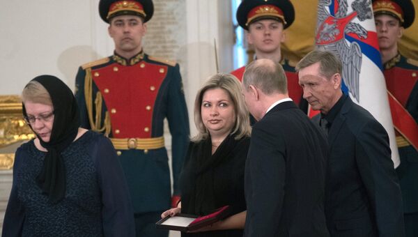 Президент РФ Владимир Путин вручает Золотую Звезду Героя РФ вдове Ольге и родителям погибшего в Сирии военного летчика гвардии майора Романа Филипова. 23 февраля 2018 Президент РФ Владимир Путин вручает Золотую Звезду Героя РФ вдове Ольге и родителям погибшего в Сирии военного летчика гвардии майора Романа Филипова. 23 февраля 2018