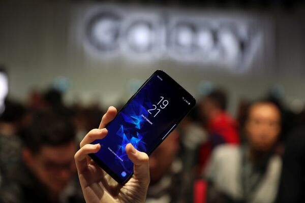 Девушка держит новый смартфон Samsung Galaxy S9 после презентации Mobile World Congress в Барселоне, Испания. 25 февраля 2018 года Девушка держит новый смартфон Samsung Galaxy S9 после презентации Mobile World Congress в Барселоне, Испания. 25 февраля 2018 года