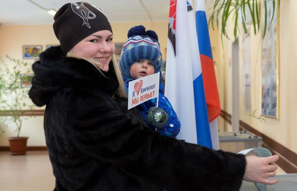 Женщина опускает бюллетень в урну на выборах президента РФ на избирательном участке №51 в Петропавловске-Камчатском. Женщина опускает бюллетень в урну на выборах президента РФ на избирательном участке №51 в Петропавловске-Камчатском.