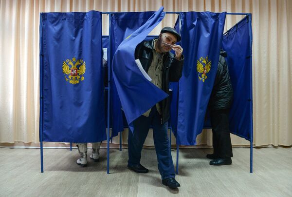 Мужчина выходит из кабинки во время голосования на выборах президента Российской Федерации на избирательном участке в Новосибирске. 18 марта 2018 Мужчина выходит из кабинки во время голосования на выборах президента Российской Федерации на избирательном участке в Новосибирске. 18 марта 2018