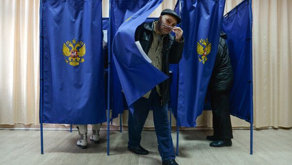 Мужчина выходит из кабинки во время голосования на выборах президента Российской Федерации на избирательном участке в Новосибирске. 18 марта 2018 Мужчина выходит из кабинки во время голосования на выборах президента Российской Федерации на избирательном участке в Новосибирске. 18 марта 2018