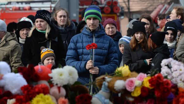 Жители несут цветы и мягкие игрушки к зданию торгового центра «Зимняя вишня» в Кемерово, где произошел пожар Жители несут цветы и мягкие игрушки к зданию торгового центра «Зимняя вишня» в Кемерово, где произошел пожар