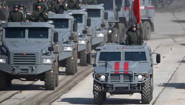 Бронированные корпусные автомобили Патруль и бронеавтомобиль Тигр во время репетиции Парада Победы на военном полигоне Алабино в Московской области Бронированные корпусные автомобили Патруль и бронеавтомобиль Тигр во время репетиции Парада Победы на военном полигоне Алабино в Московской области