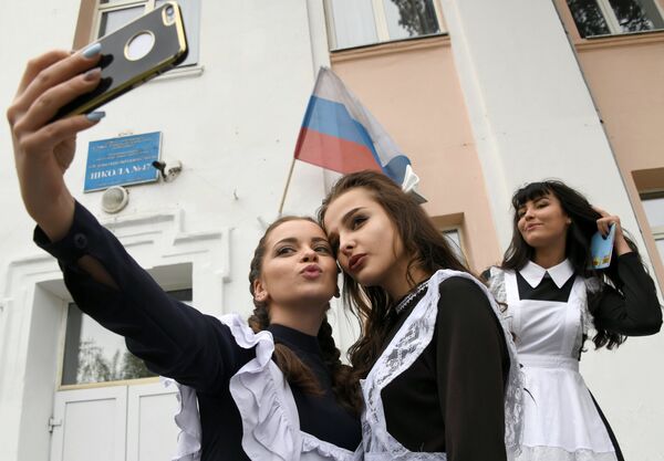 Выпускницы делают селфи у входа в школу №47 во время празднования последнего звонка в городе Чите Выпускницы делают селфи у входа в школу №47 во время празднования последнего звонка в городе Чите