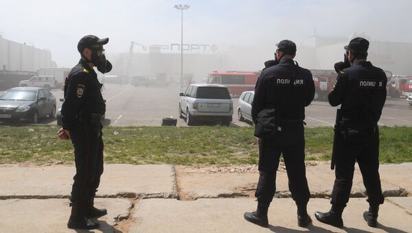 Сотрудники полиции и пожарная техника перед зданием торгового центра Порт в Казани, где произошло возгорание Сотрудники полиции и пожарная техника перед зданием торгового центра Порт в Казани, где произошло возгорание