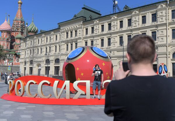 Молодые люди фотографируются рядом с символикой, посвященной предстоящему чемпионату мира по футболу 2018 в Москве Молодые люди фотографируются рядом с символикой, посвященной предстоящему чемпионату мира по футболу 2018 в Москве