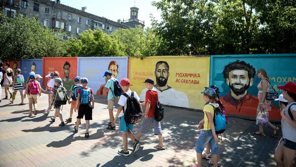 Дети на фоне граффити-портретов футболистов восьми сборных на бетонном заборе на пересечении улиц Советской и Комсомольской в Волгограде в рамках проведения чемпионата мира по футболу 2018 Дети на фоне граффити-портретов футболистов восьми сборных на бетонном заборе на пересечении улиц Советской и Комсомольской в Волгограде в рамках проведения чемпионата мира по футболу 2018