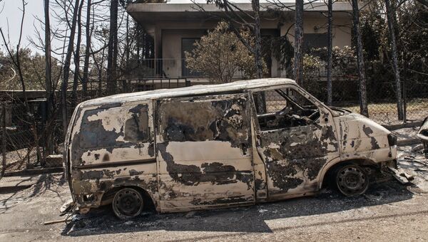 Сгоревший в результате лесных пожаров автомобиль на улице Мати в Греции. Архивное фото Сгоревший в результате лесных пожаров автомобиль на улице Мати в Греции. Архивное фото