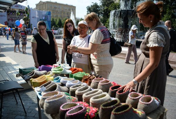 Посетители у прилавка с валяной обувью на фестивале Многонациональная Россия в Москве Посетители у прилавка с валяной обувью на фестивале Многонациональная Россия в Москве