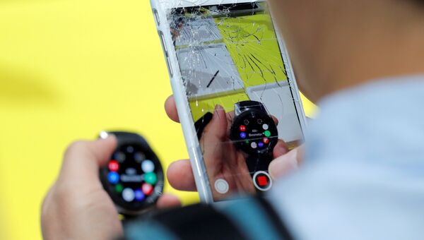 Посетитель фотографирует на iPhone часы Samsung Galaxy Watch на презентации Galaxy Unpacked в Нью-Йорке Посетитель фотографирует на iPhone часы Samsung Galaxy Watch на презентации Galaxy Unpacked в Нью-Йорке