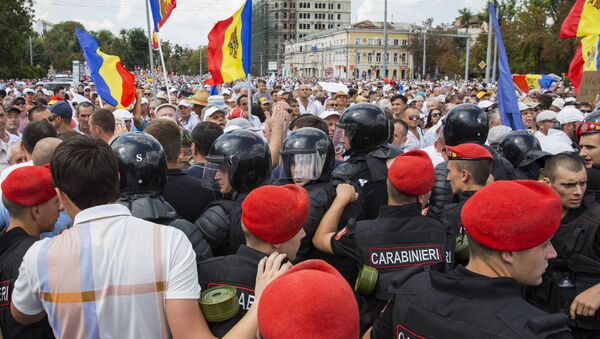 Сотрудники правоохранительных органов и участники акции протеста, требующие отставки правительства, в Кишиневе. 26 августа 2018 Сотрудники правоохранительных органов и участники акции протеста, требующие отставки правительства, в Кишиневе. 26 августа 2018